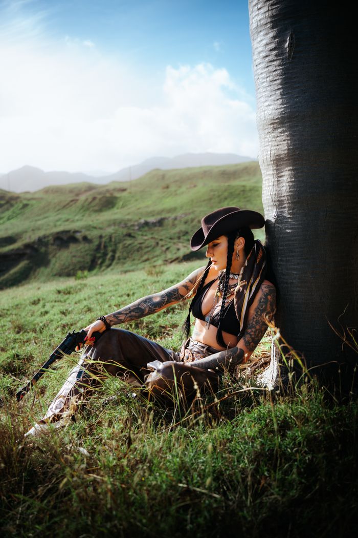 The Art of Drawing Readers In: Your attractive post title goes here A woman in a cowboy hat relaxes against a tree in scenic Madère, Portugal.