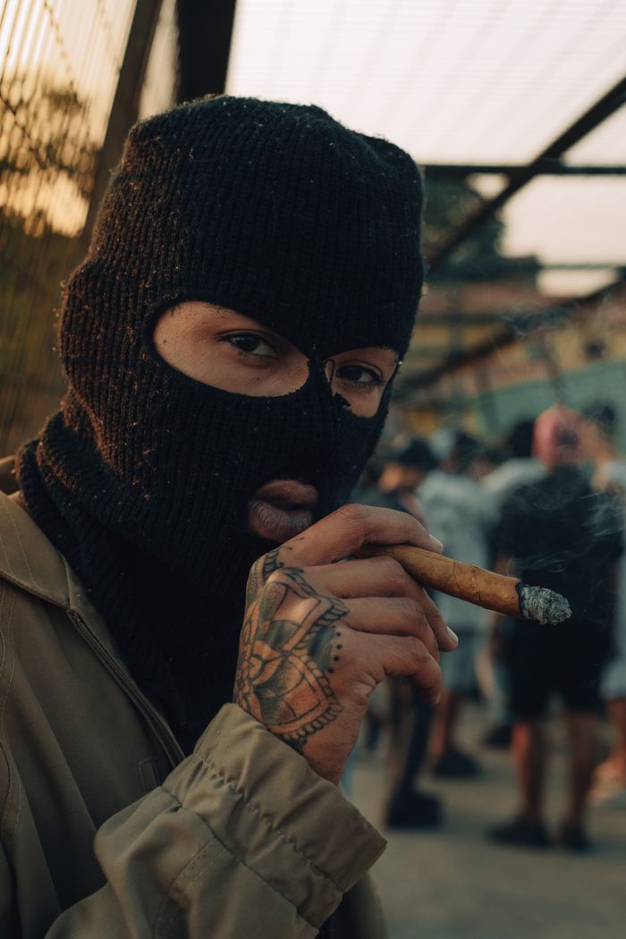 Crafting Captivating Headlines: Your awesome post title goes here Close-up of a person wearing a balaclava and smoking a cigar outdoors, adding mystery and intrigue.
